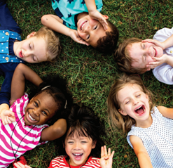 Children lying in a circle in the grass